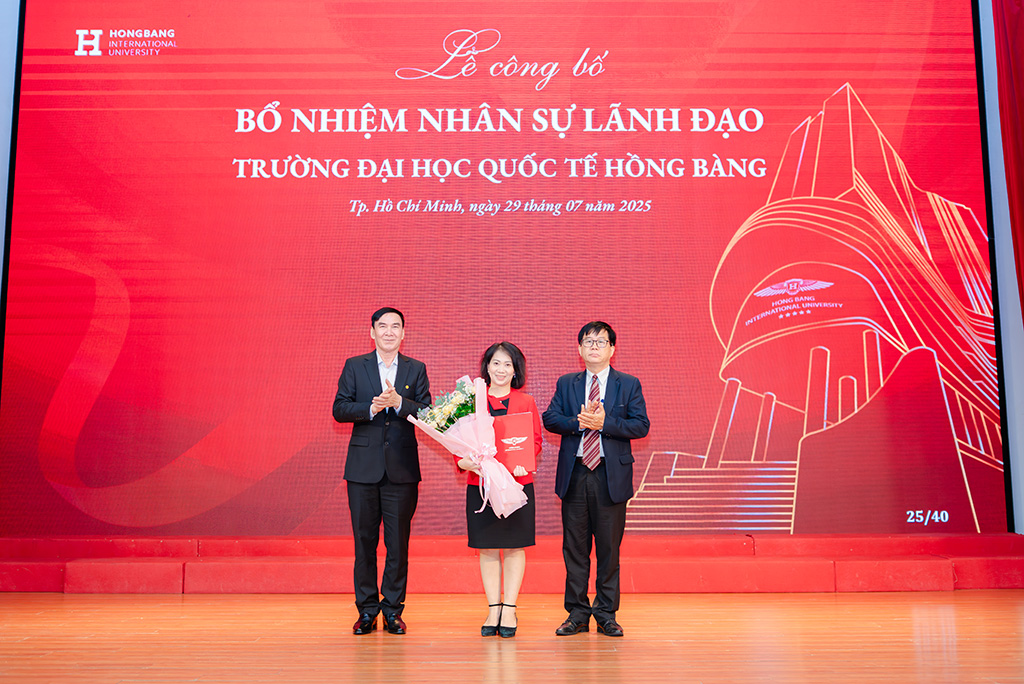 PGS.TS PGS.TS Nguyễn Bá Hoàng - Chủ tịch Hội đồng trường (bìa phải) và GS.TS.BS Phạm Văn Lình (bìa trái) trao quyết định và tặng hoa chúc mừng tân Phó Hiệu trưởng PGS.TS.DS Nguyễn Thị Thu Thủy 