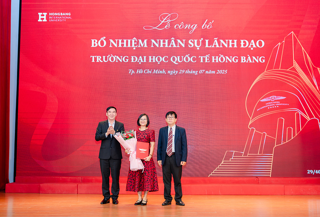 PGS.TS PGS.TS Nguyễn Bá Hoàng - Chủ tịch Hội đồng trường (bìa phải) và GS.TS.BS Phạm Văn Lình (bìa trái) trao quyết định và tặng hoa chúc mừng tân Phó Hiệu trưởng  Lương Thị Kim Chi