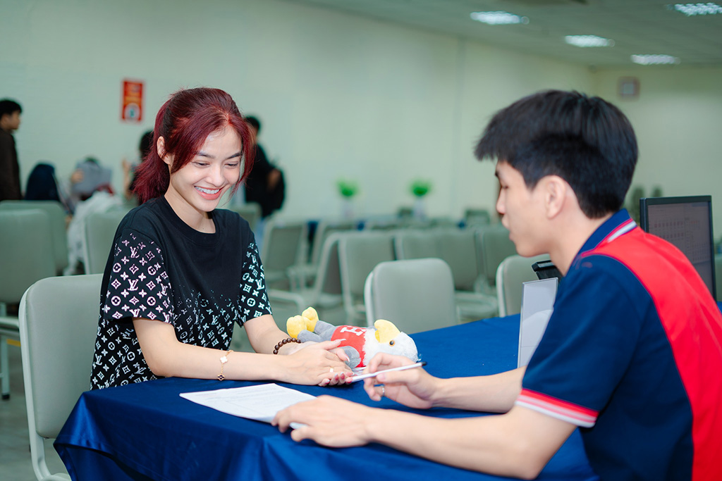 Á hậu cười rạng ngỡ trong khi nghe phổ biến về quy chế, lịch học và các hoạt động dành cho tân sinh viên HIU